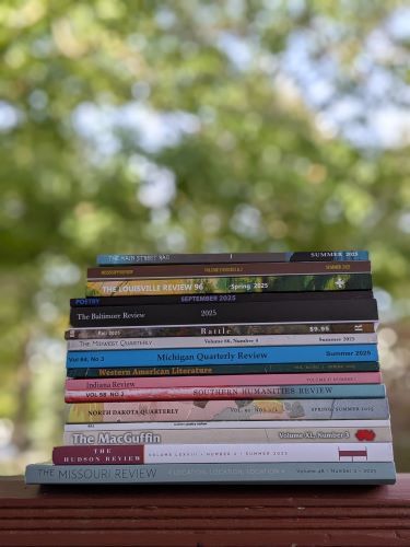 stack of magazines outside with trees in the background